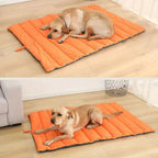 Dog lying on an orange and gray quilted mat in a home setting.